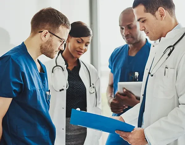 Medical-doctors-and-nurse-practitioners-discuss-paperwork-in-a-hallway.jpg